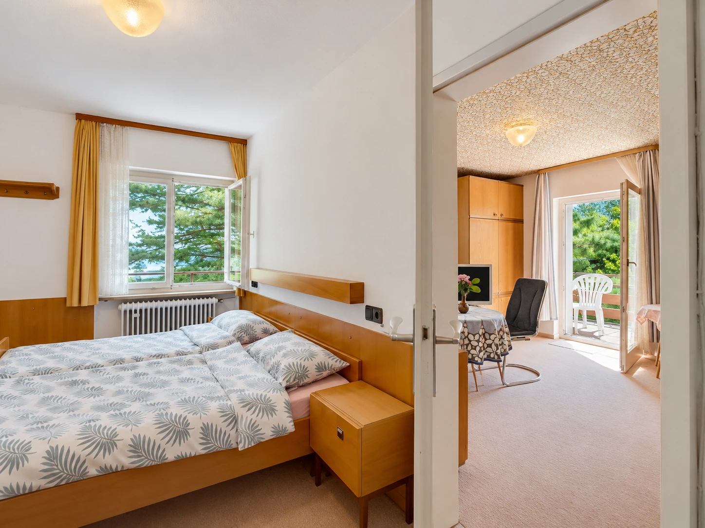 Schlafzimmer mit Blick durch die offene Tür in den Wohnbereich